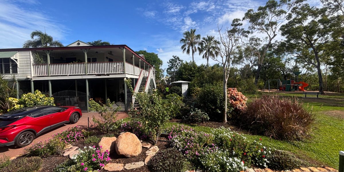 Garden bed with tropical plants, rock edging, and birdbath feature after complete maintenance and mulching in Darwin.